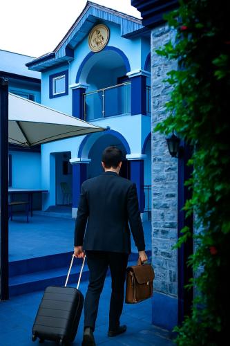 a man in a suit pulling a suitcase at Luxurious Lukes Apartment in Benin City