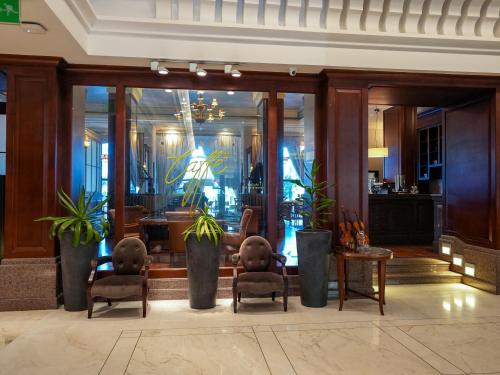 a lobby with two chairs and a table with plants at Sheraton Dammam Hotel & Convention Centre in Dammam