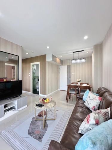a living room with a brown leather couch and a table at The City Hatyai D61 in Sathani Khlong Rian