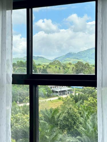 a window with a view of a mountain view at The City Hatyai D61 in Sathani Khlong Rian
