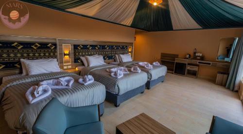 a hotel room with two beds with towels on them at Mars Land Luxury Camp in Wadi Rum