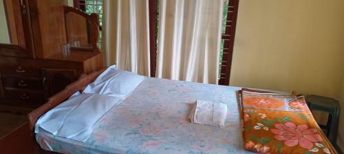 a bedroom with a bed with a pillow on it at East West Farm Homestay in Munnar