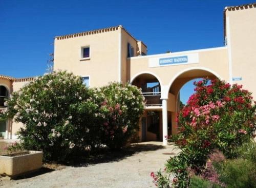 乐巴凯尔斯Superbe appartement terrasse piscine proche plage的前面有灌木和鲜花的建筑