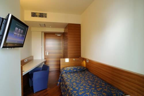 a hotel room with a bed and a flat screen tv at Hotel Le Roi in Varazze