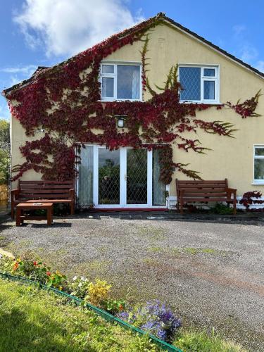 a house with two benches in front of it at Lake View House in Moyard