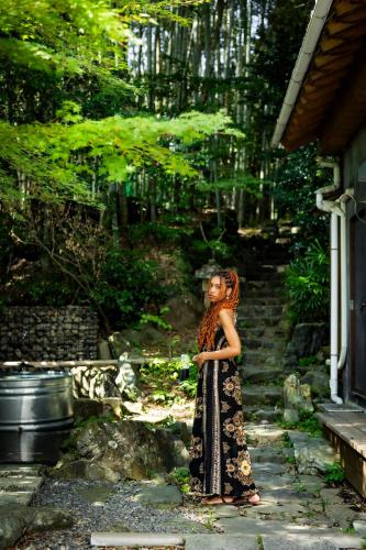 a woman in a dress standing in a garden at Uwanosora Bed&BBQ&Sauna in Shizuoka