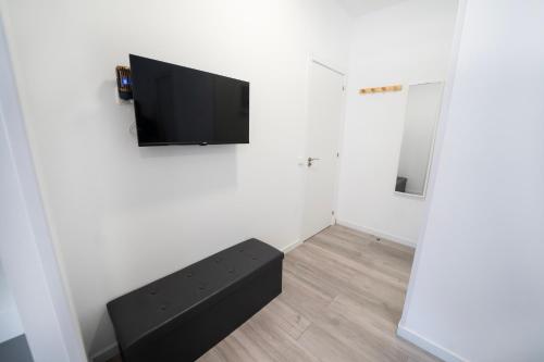 a living room with a tv on a wall at En Madrid, amplio, especial grupos o familias in Leganés