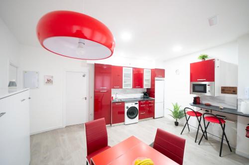 a kitchen with red cabinets and a red table and chairs at En Madrid, amplio, especial grupos o familias in Leganés