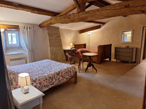 une chambre avec un lit et une table dans une pièce dans l'établissement Logis de Bois Roche 1, à Saint-Bonnet-sur-Gironde