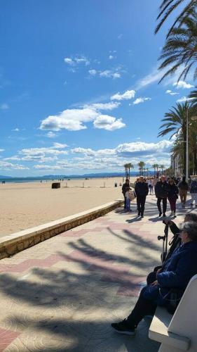 a person sitting on a bench on the beach at Medusa Felix in Cullera