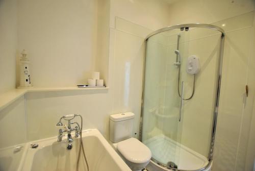a bathroom with a shower and a toilet and a sink at Ard na Mara- Coastal Apartment in Pittenweem