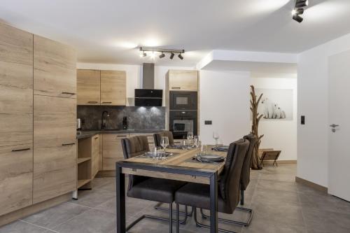 Les ChavantsThe Bear - Sauna Piscine - Face au Kandahar的厨房里设有1间带桌椅的用餐室