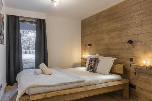 Les ChavantsThe Bear - Sauna Piscine - Face au Kandahar的卧室里有一张床，墙是木的