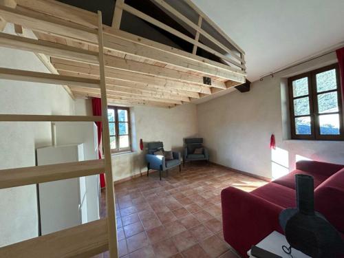 un salon avec un canapé et une mezzanine dans l'établissement maison de village , chaleur, baignades et terroir en drôme, à Cornillon-sur-lʼOule