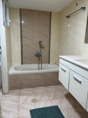 a bathroom with a shower and a tub and a sink at פנינת הדגן 32 in El ‘Affūle
