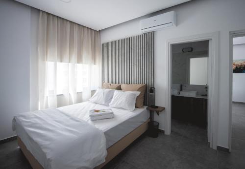 a bedroom with a white bed and a bathroom at Le Bouquet Luxury Suites Ltd in Nicosia