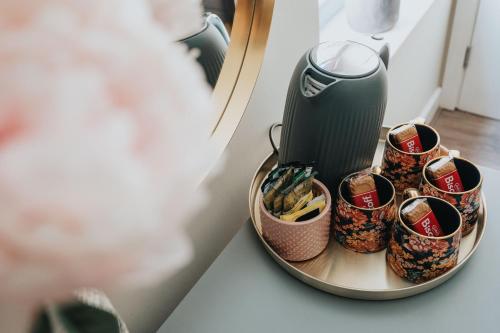 a table with a coffee maker and cups on a plate at RST Bramley Boutique in Liverpool