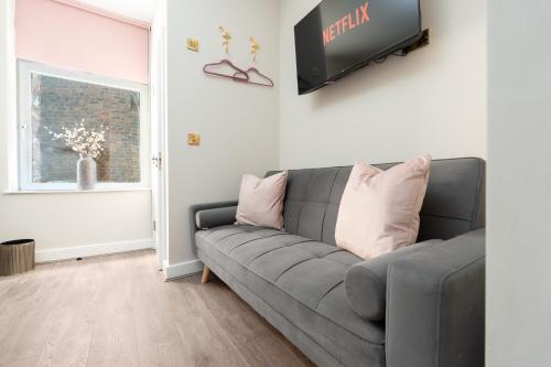 a living room with a gray couch and a tv at RST Bramley Boutique in Liverpool
