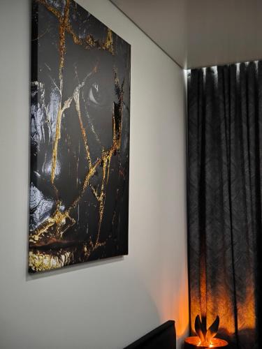 a painting hanging on a wall with a lamp at DOMINO apartamentai, SELF CHECK-IN in Panevėžys