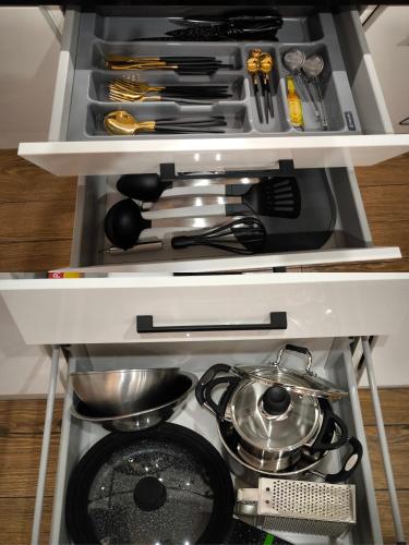 a drawer filled with lots of kitchen utensils at DOMINO apartamentai, SELF CHECK-IN in Panevėžys