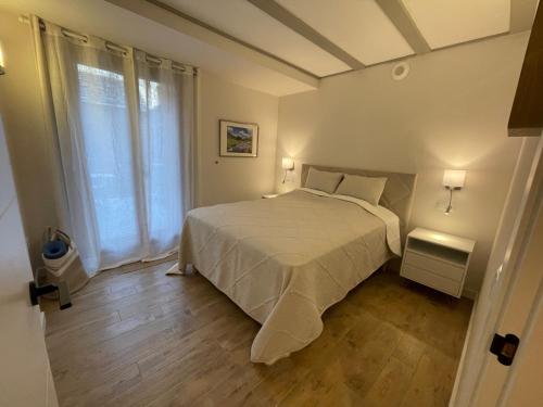 a bedroom with a white bed and a large window at Villmor - B23 - Corazón del Casco in Benasque