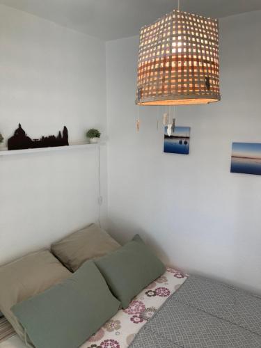 a room with a bed in the corner with a light at Le Bulot Bleu *Terrasse couverte *Parking *2 vélos in Carnac