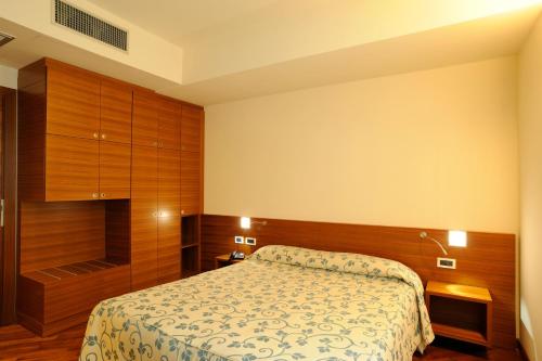 a hotel room with a bed and a closet at Hotel Le Roi in Varazze