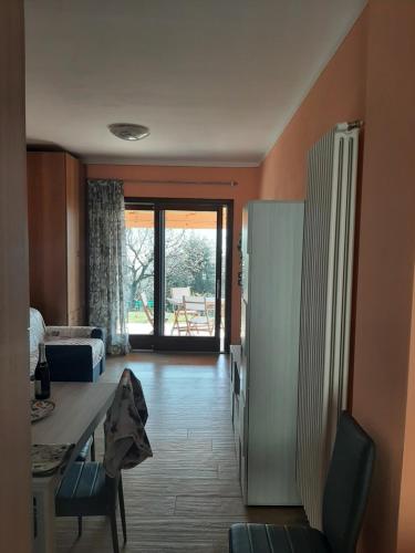 a living room with a table and a refrigerator at Dolce Luna in Gargnano