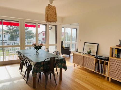 - un salon avec une table à manger et des chaises dans l'établissement Appartement 3 chambres, très lumineux, plages et centre ville à pied, à Biarritz