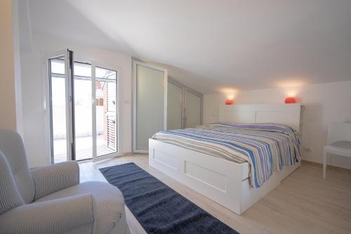 una camera da letto bianca con un letto e una sedia di Il Topazio a Vasto