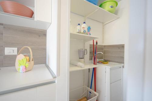 una piccola cucina con armadi bianchi e scaffali di Il Topazio a Vasto