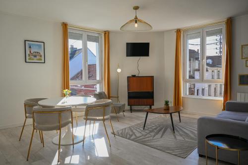 un salon avec un canapé, une table et des chaises dans l'établissement Calais Chic 2-4 personnes Centre Ville, à Calais