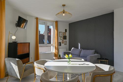 un salon avec une table et un canapé dans l'établissement Calais Chic 2-4 personnes Centre Ville, à Calais