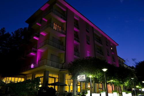 ein Gebäude mit lila Lichtern an der Seite in der Unterkunft Hotel Mediterraneo in Chianciano Terme