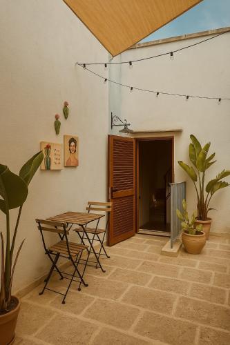 a room with a table and chairs and plants at Corte San Giorgio in Matino