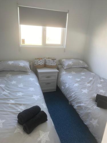 two beds sitting next to each other in a bedroom at Beach Bay Holiday Home in Camber