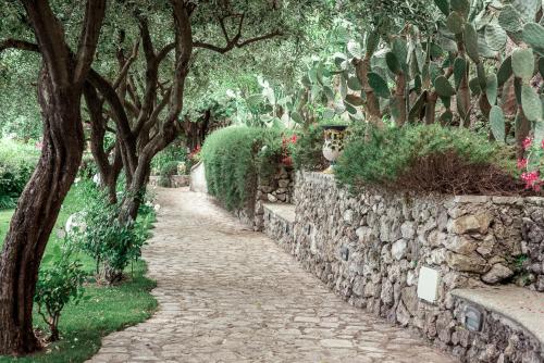 a stone path with trees and a stone wall at Villa San Cosma in Ravello