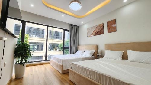 a bedroom with two beds and a large window at Timi Homestay Near the Wave Park Ocean Park 2 in Hòa Bình