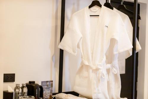 a white shirt is hanging on a rack at Myhotel Cmyk@Ratchada in Bangkok