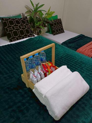a crate of water bottles and towels on a bed at Near Central Hatyai#Asean Night Bazaar Market in Hat Yai