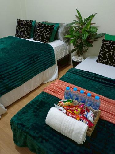 a room with two beds with drinks and a tray of food at Near Central Hatyai#Asean Night Bazaar Market in Hat Yai