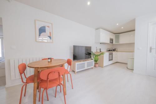 - une cuisine avec une table en bois et des chaises orange dans l'établissement Ananas - Parking privé, à Moissy-Cramayel