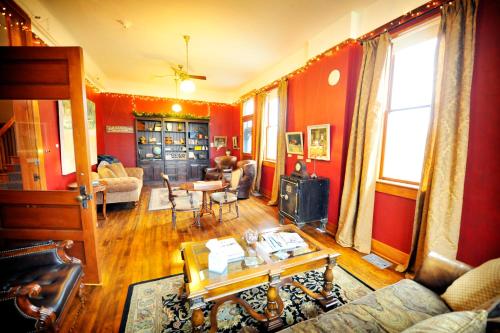 a living room with red walls and a couch and a table at Balch Hotel in Dufur