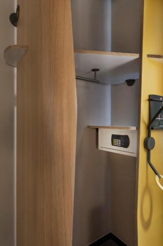 a small kitchen with a clock in a closet at ibis Jerusalem city Center - An AccorHotels Brand in Jerusalem