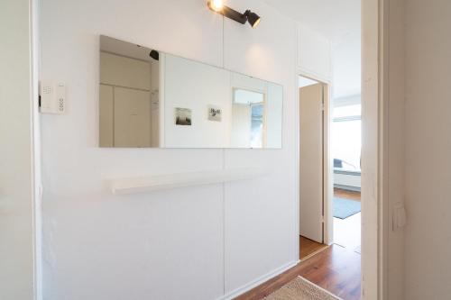 a room with white cabinets and a mirror on the wall at Leuchtturm-Loft mit Meerblick in Sierksdorf