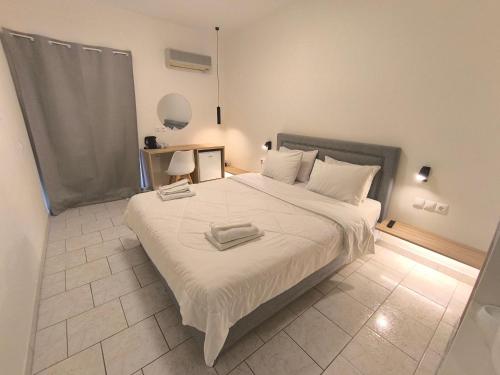 a bedroom with a large bed with two towels on it at Koukounari Agistri in Skala