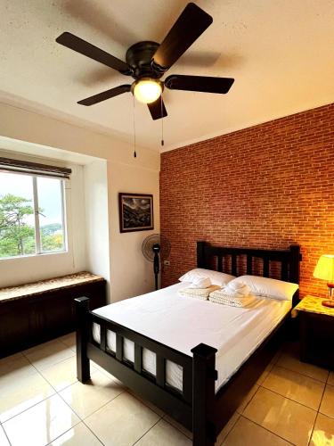 a bedroom with a bed with a ceiling fan at Room in Albegro Baguio Burnham Wifi Parking in Baguio