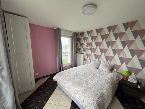 - une chambre avec un lit et un mur géométrique dans l'établissement Attique avec terrasse - Zénith & centre-ville, à Strasbourg