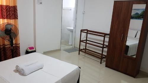a room with a bed and a mirror and a sink at Serene Kandy Getaway with City Views in Kandy