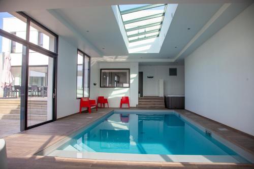 a swimming pool in a house with a skylight at Villa Pool and Beach Bretagne in Plouescat